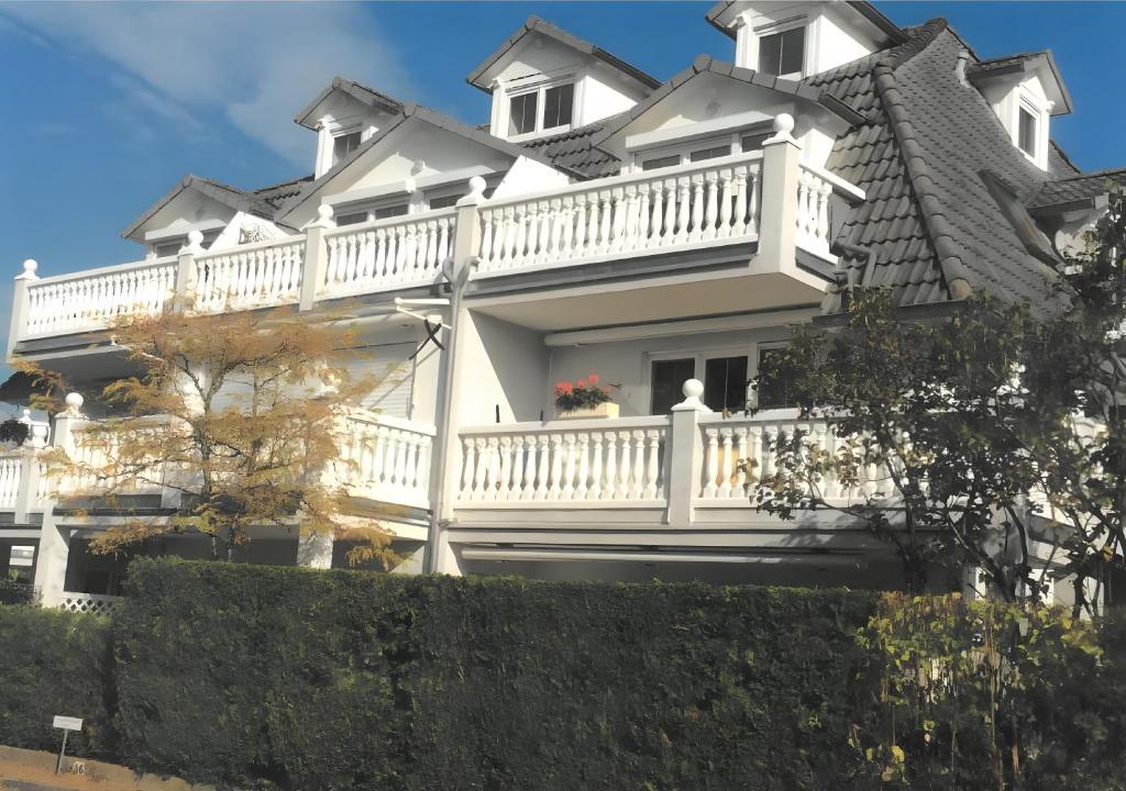a large white house with a balcony at Ferienwohnung am Schlosssee in Salem