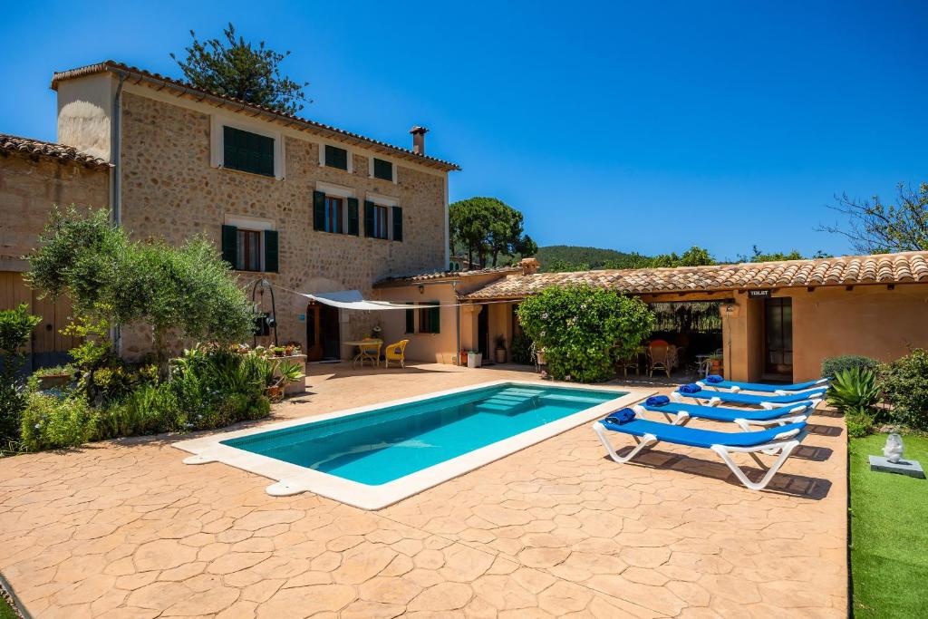 a villa with a swimming pool and lounge chairs at Villa Frontera in Sóller