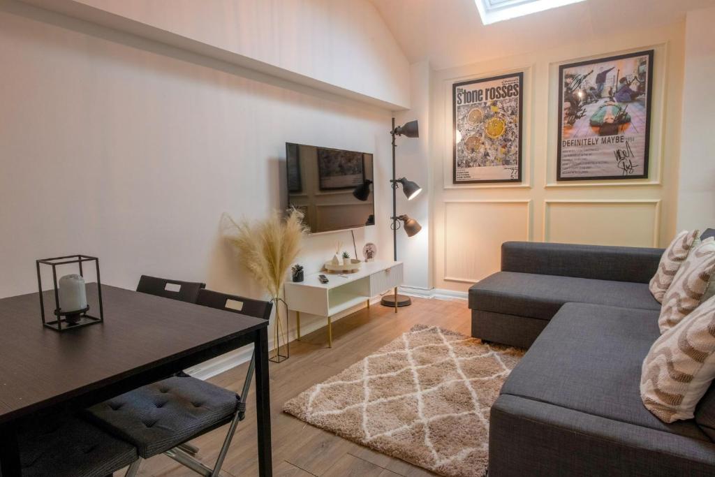 a living room with a couch and a table at Apartment in cite center in Manchester