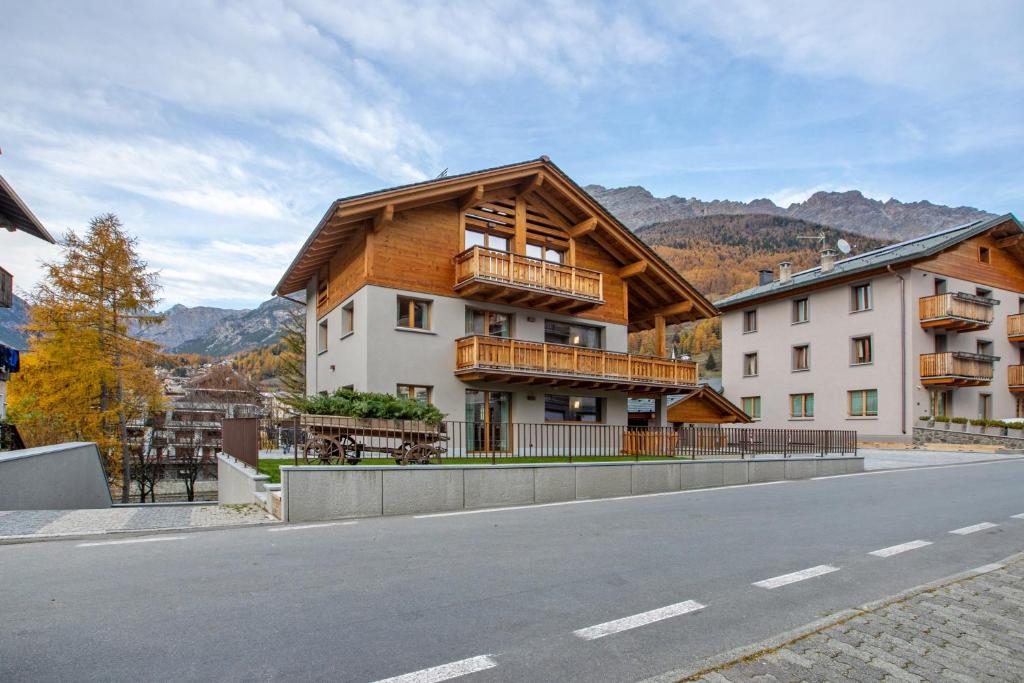 ein Gebäude mit Balkon an der Straßenseite in der Unterkunft Quattropassi Bormio in Bormio