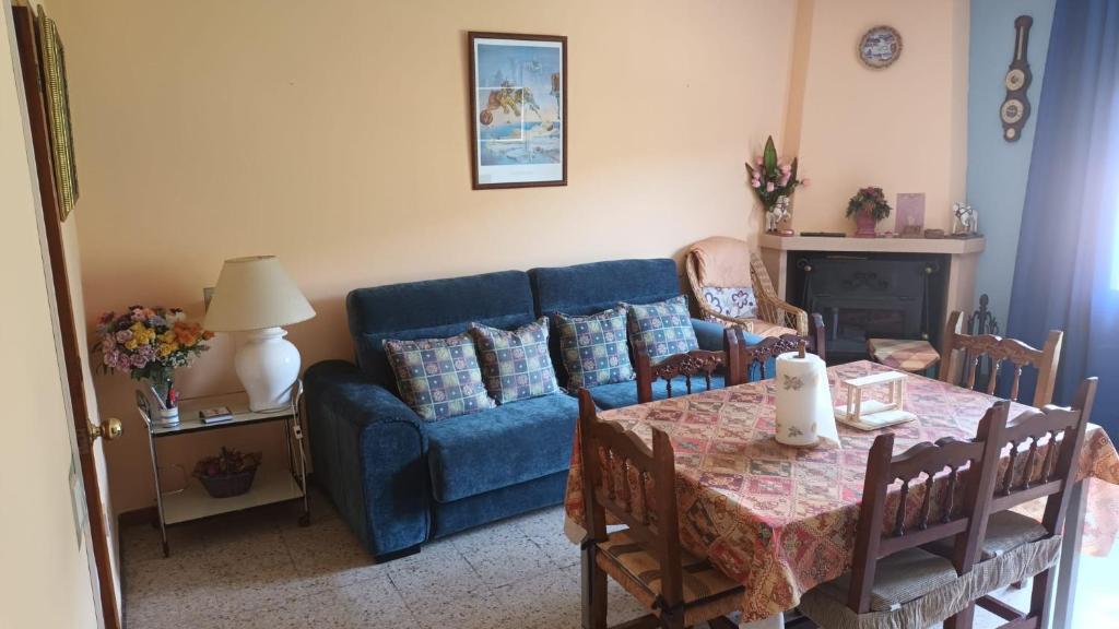 a living room with a blue couch and a table at Casa Johana in El Arenal