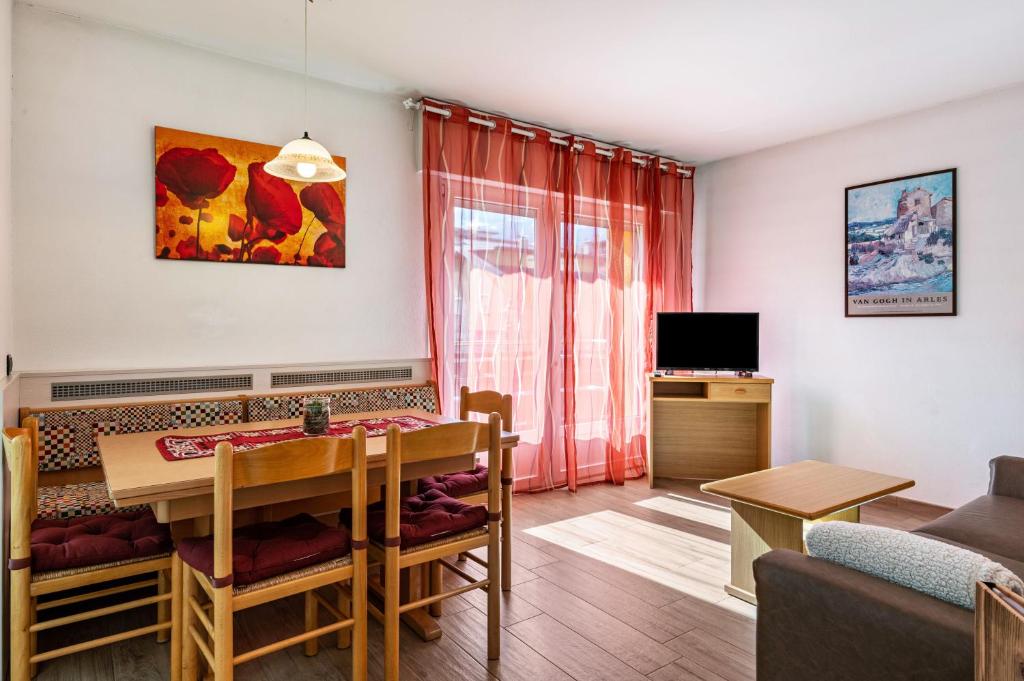 a living room with a dining room table and a couch at Casa Mara in Predazzo