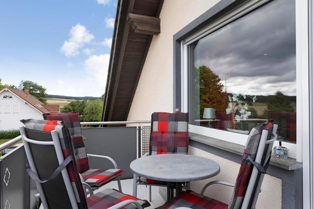 a balcony with a table and chairs and a window at Haus Claudia in Fulda
