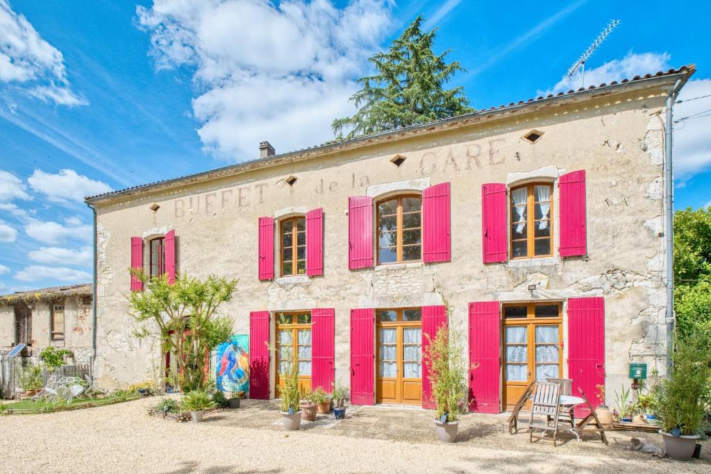 an old stone building with red shutters at Logement Le Buffet De La Gare in Falgueyrat