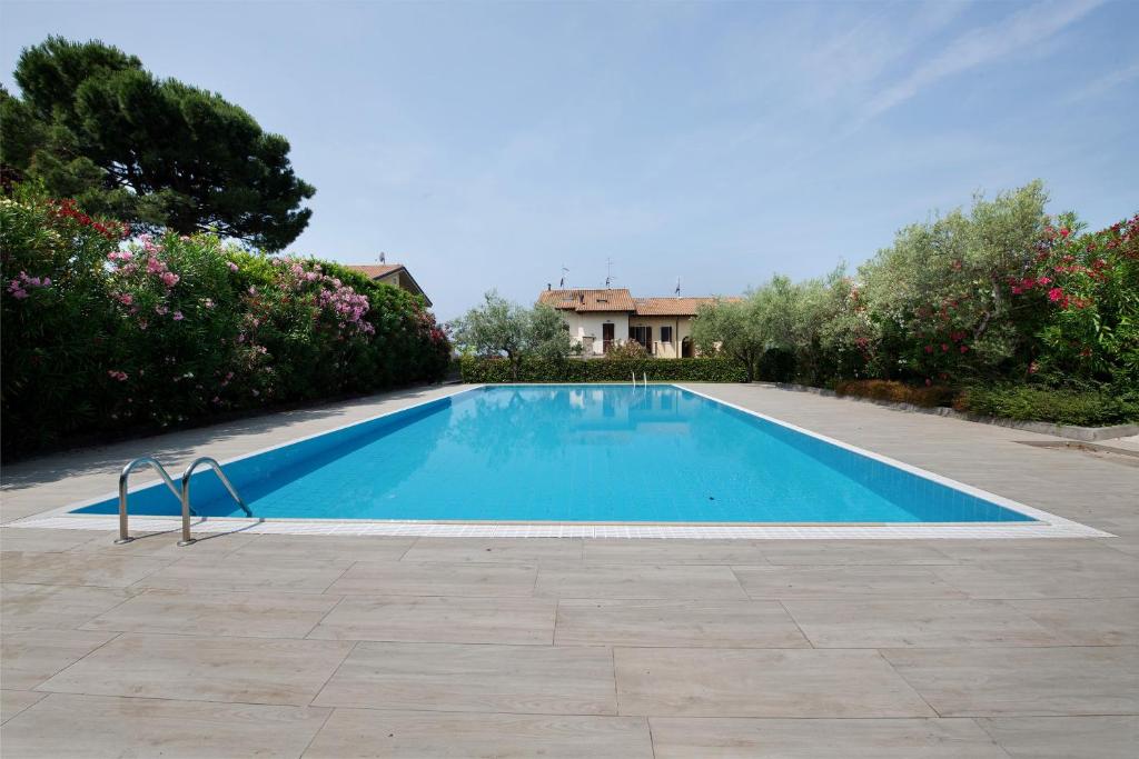 a swimming pool in a yard next to a house at Residence Bardolino in Bardolino