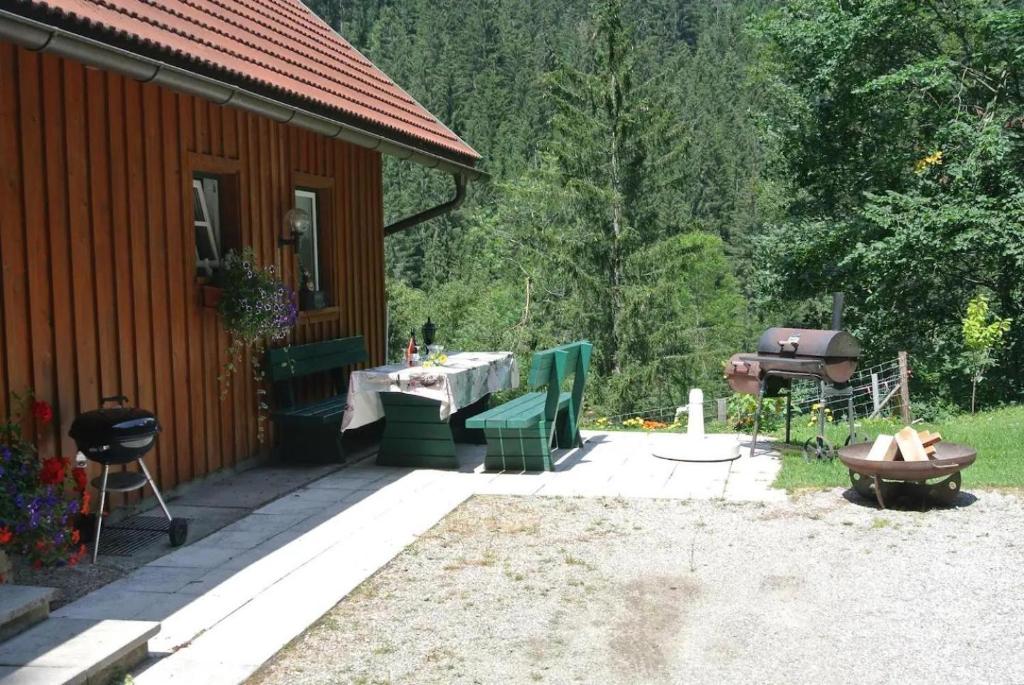 a patio of a cabin with a barbecue and a grill at Ferienhaus Waldenstein 1 in Waldenstein