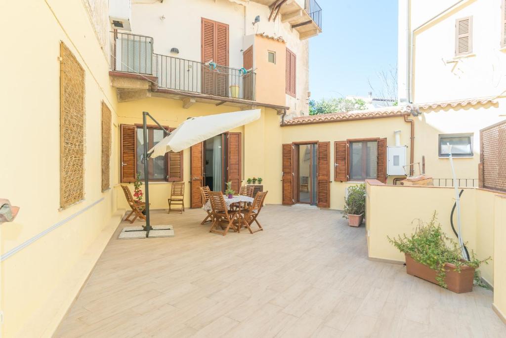 an outdoor patio with a table and an umbrella at Rifla Vacanze in La Maddalena