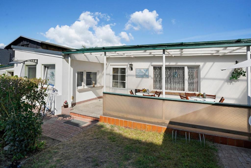 a white house with a bench in the yard at Ferienbungalows Werner in Koserow