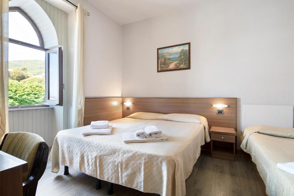 a hotel room with two beds and a window at Appartamento Bilocale Moneglia 37 in Moneglia