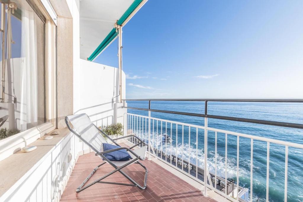 a chair sitting on a balcony looking out at the ocean at La finestra sul mare in Ospedaletti