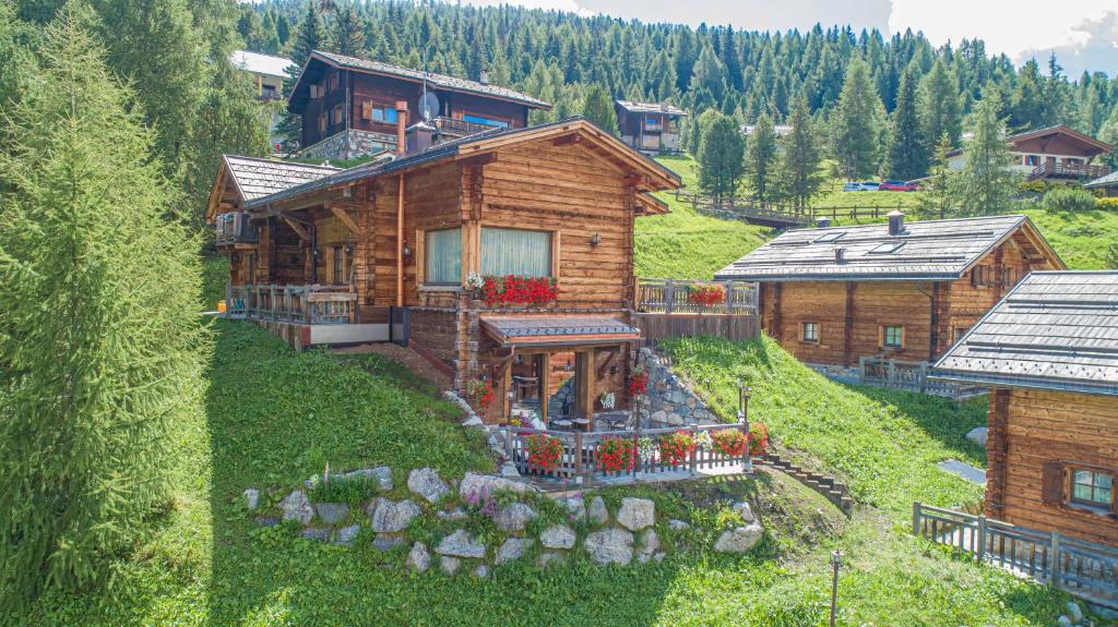 an aerial view of a log house on a hill at Le Chalet Suite Livigno in Livigno