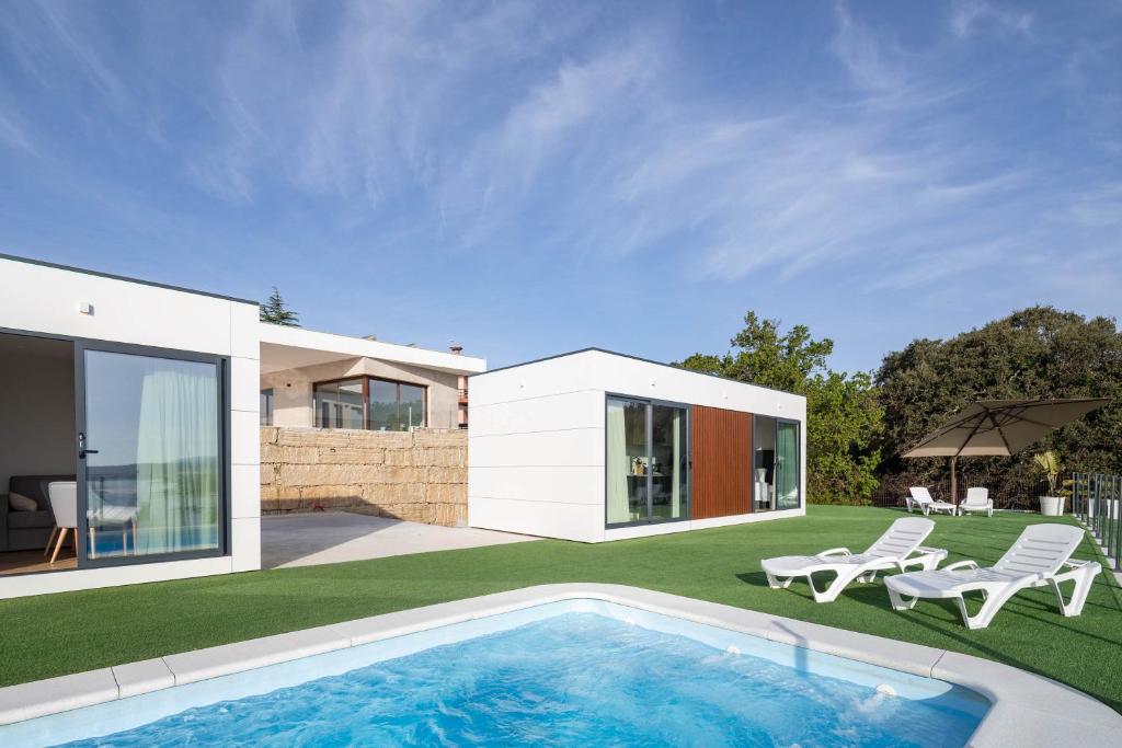 a house with a swimming pool in the yard at Complejo Bungalow con piscina in A Pobra do Caramiñal