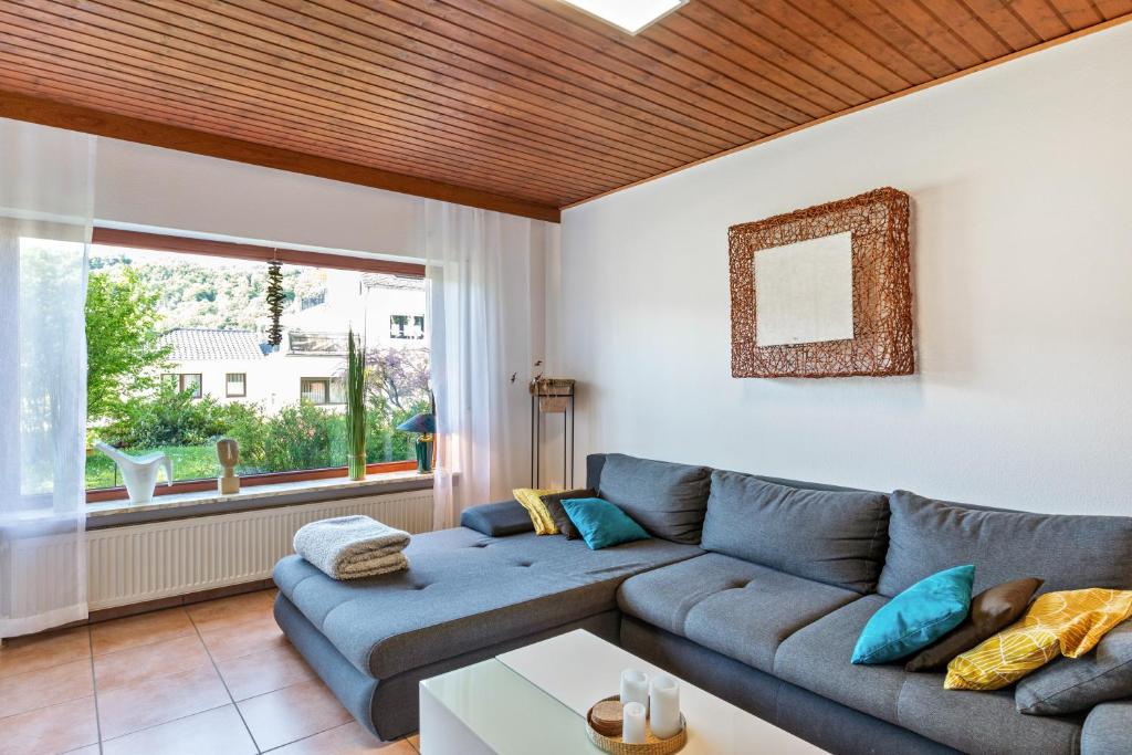 a living room with a blue couch and a window at Ferienwohnung Wanderbar in Kamp-Bornhofen