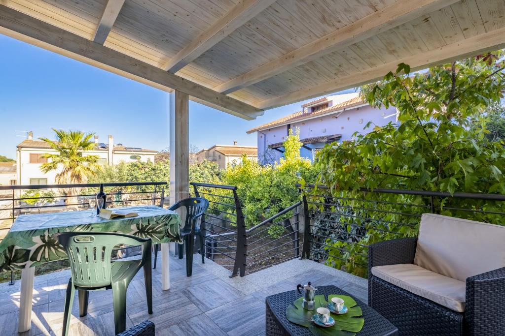 a patio with a table and chairs on a balcony at Appartamento Latorre in Bari Sardo