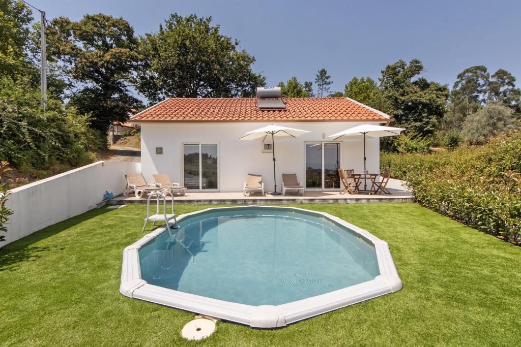 a small swimming pool in the yard of a house at Refugio Das Vinhas in Celorico de Basto