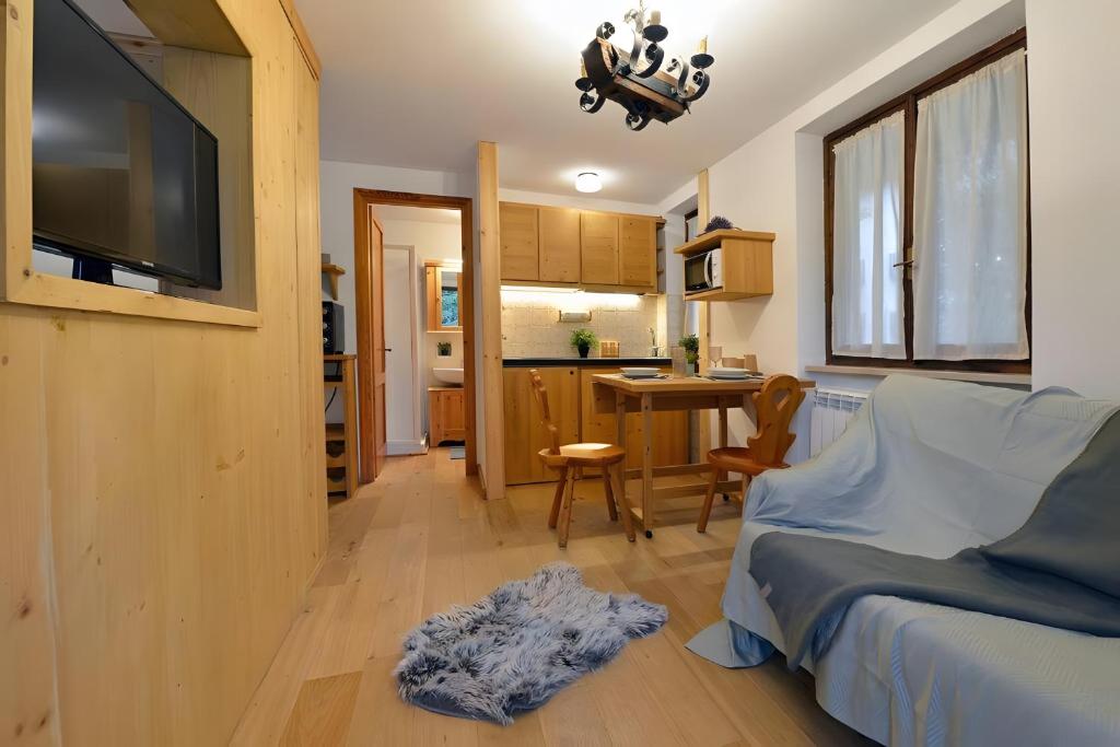 a bedroom with a bed and a desk and a kitchen at Petit Bijou Morgex in Morgex