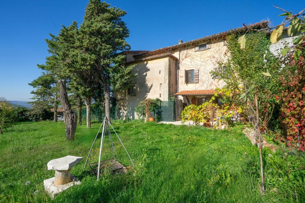 an old house in a grassy yard with a house at Col Di Metino - Umbria in Gualdo Tadino