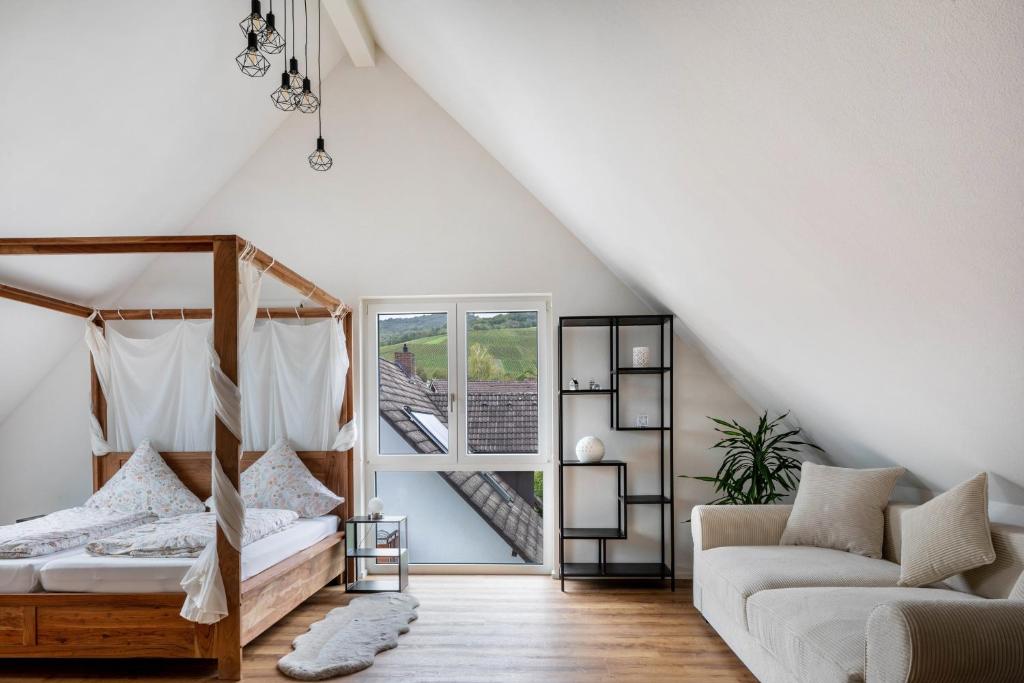 a bedroom with a bed and a couch and a window at Ferienhaus Ebringen in Ebringen