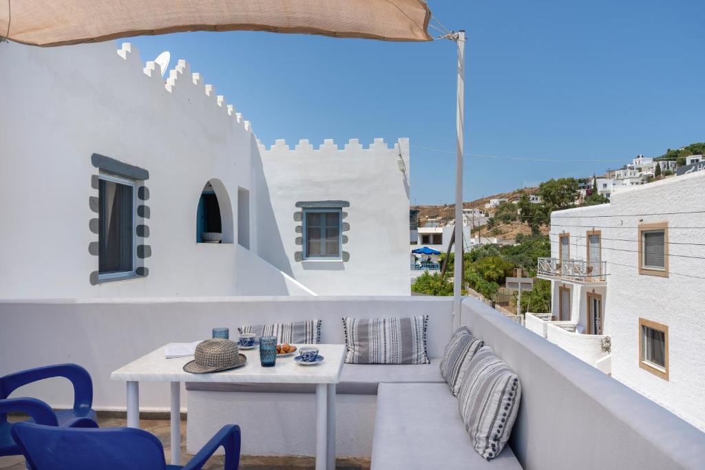 a white balcony with a table and chairs at Pico Bello Patmos 30 in Patmos