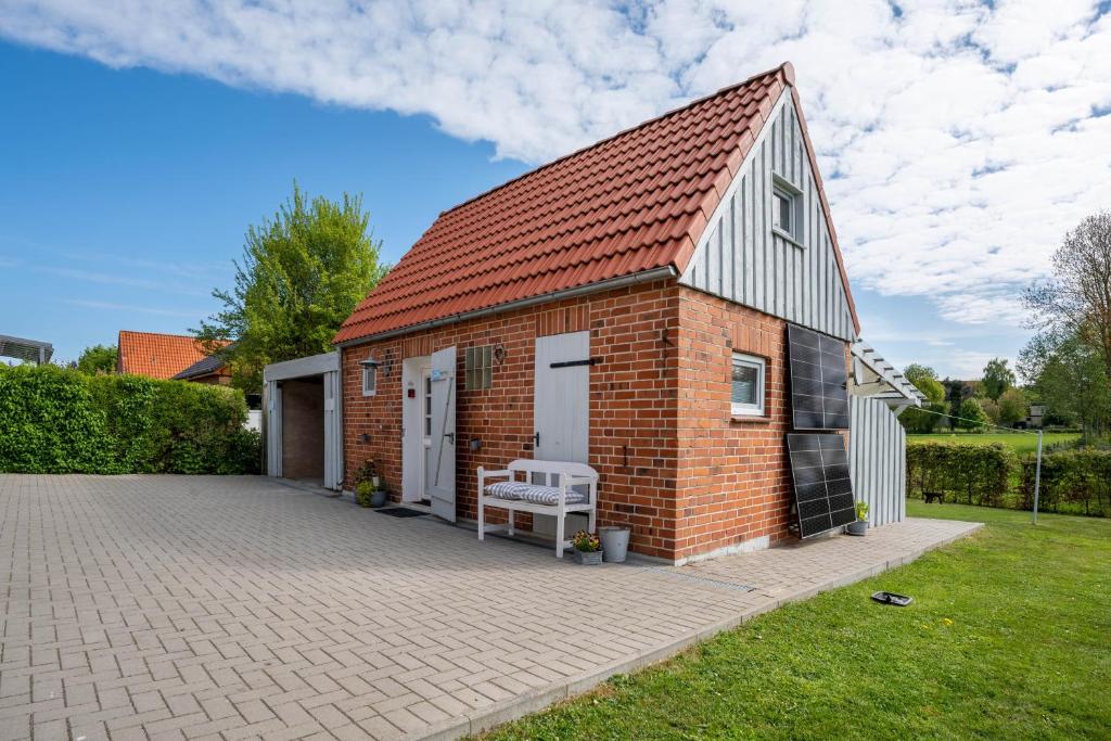 a brick building with a bench on a driveway at Bezauberndes Lütt Hus in Damlos