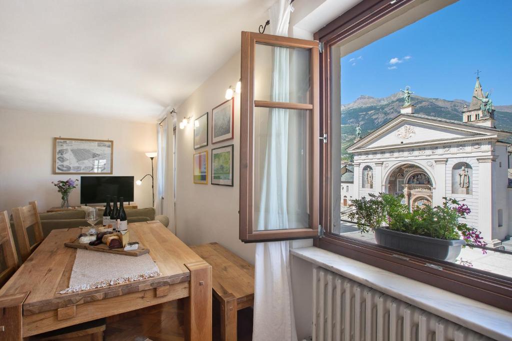 a living room with a large window and a table at Maison Gnemaz Grand Combin in Aosta