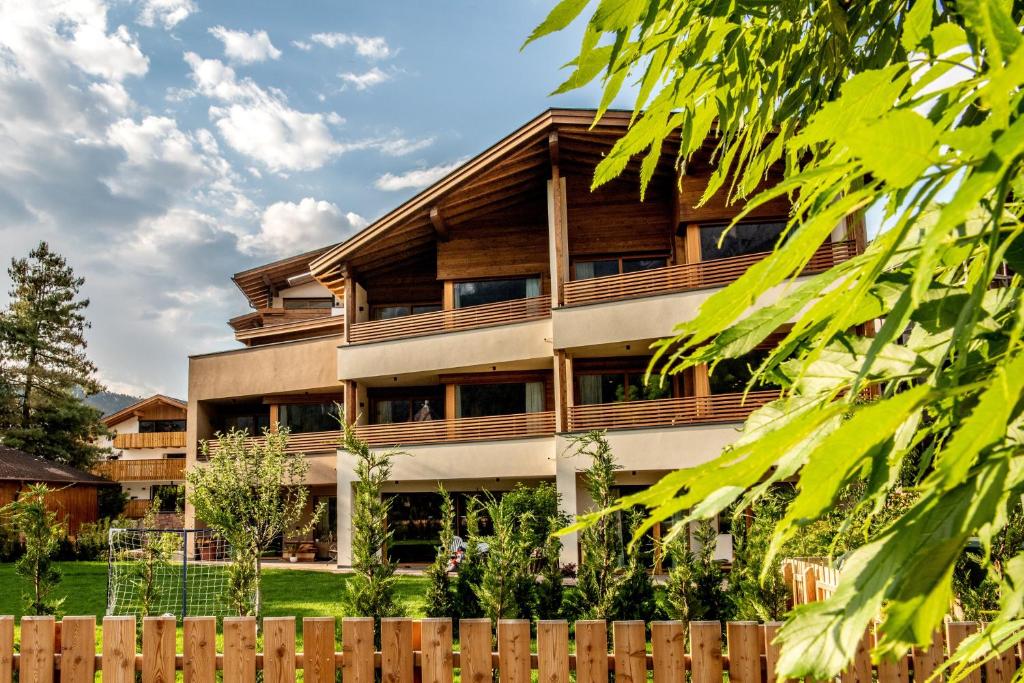 an apartment building with wooden balconies and a fence at Mysciliar Apartment Tree ii in Siusi