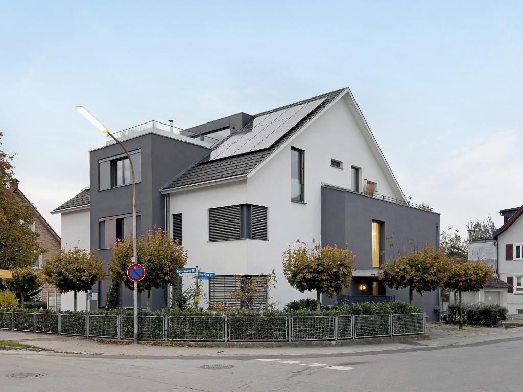 a white house with a black roof on a street at Kapps Haus in Langenargen