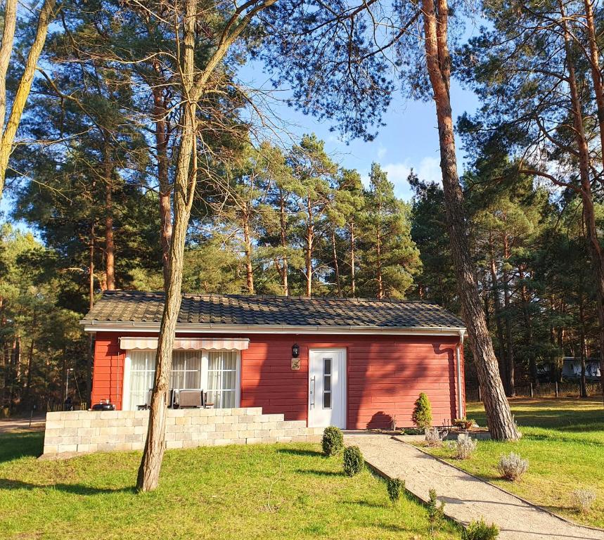 a small red house in the middle of a yard at Ferienhaus Eichelhäher in Zossen
