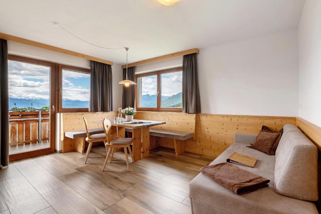 a living room with a couch and a table at Forchnerhof Apt Rose in Maranza