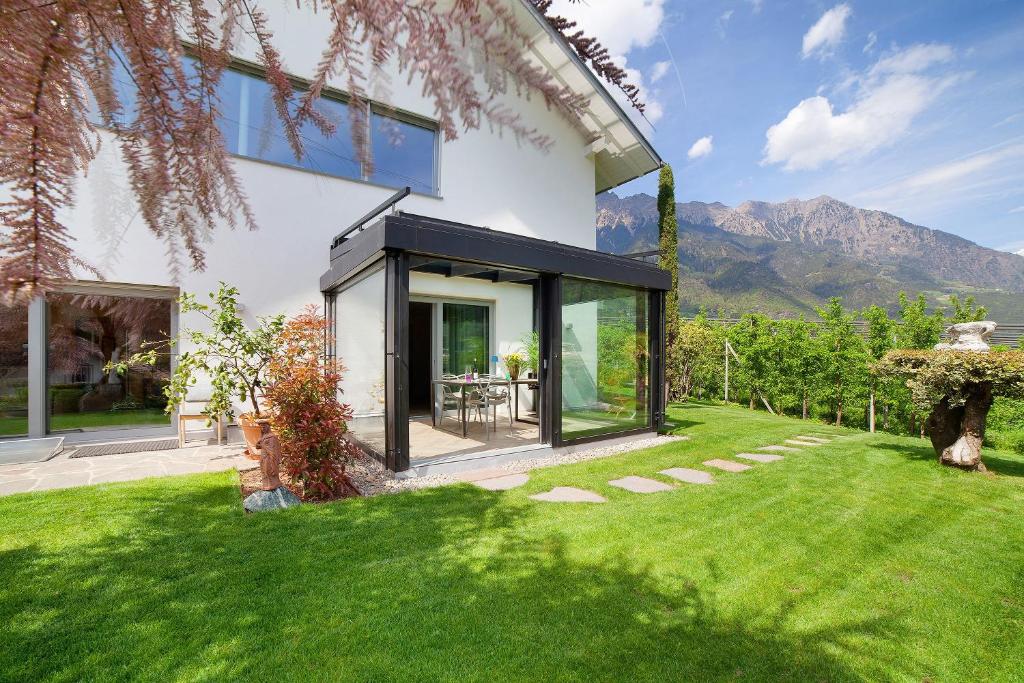 a glass house with a table in a yard at Casa Sonngart in Parcines