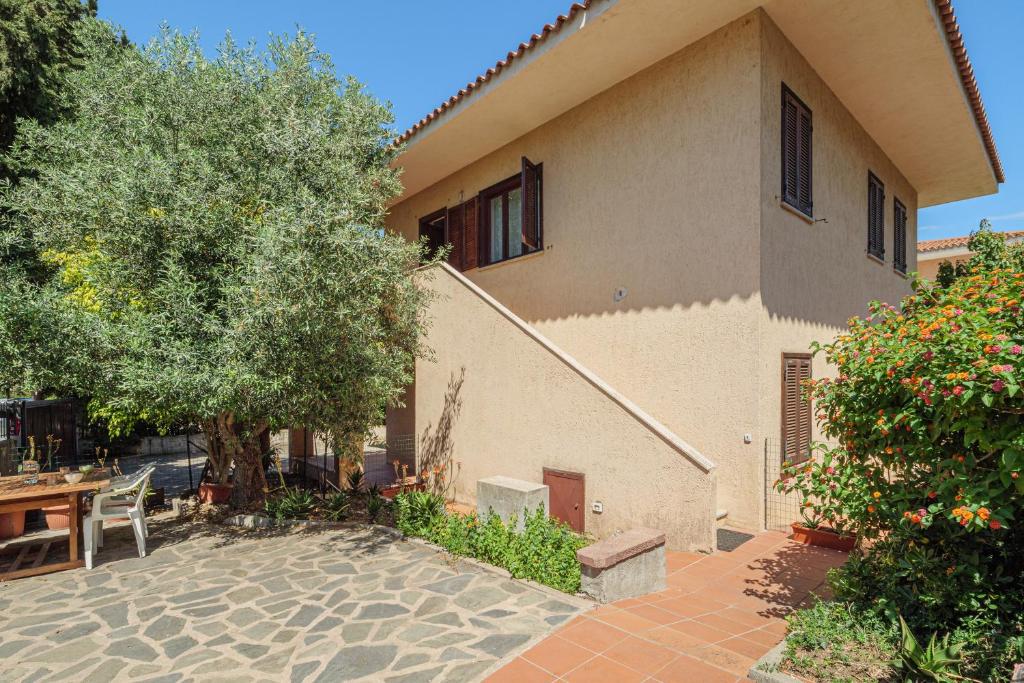 a house with a patio with a table and a tree at Quadrilocale Via D'annunzio in San Teodoro