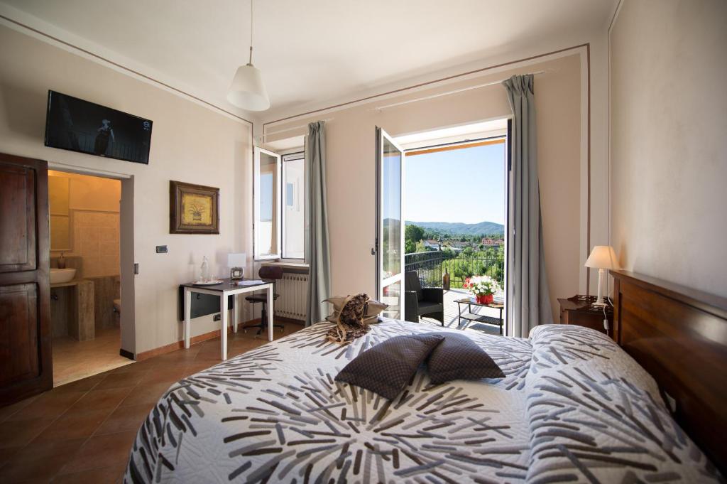 um quarto com uma cama e uma grande janela em B&B Borgo Cortese em Gavi