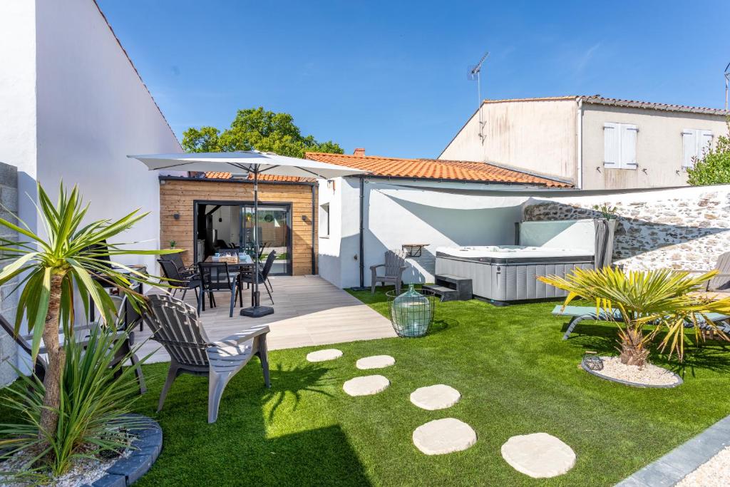 a backyard with a table and chairs and grass at La Goisette in Beauvoir-sur-Mer