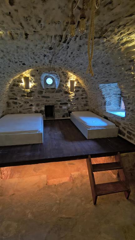 two beds on a table in a stone room at Pyrgos Mitsakou 2 in Vathia