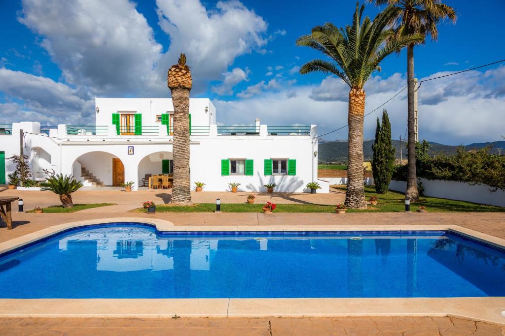 a villa with a swimming pool in front of a house at Finca Goet in Sa Pobla