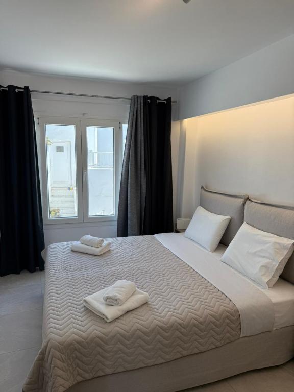 a bedroom with a large bed with two towels on it at Nice & cosy central studios in Mikonos