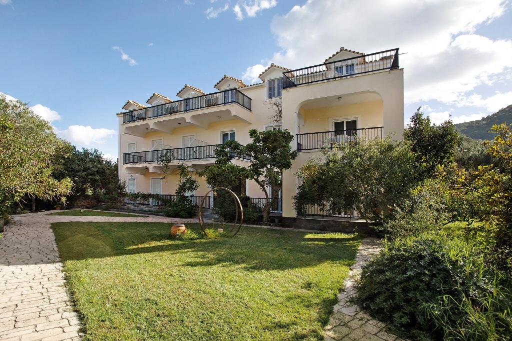 a large white building with a yard in front of it at Dolphin Apartment Sea View 9 in Keri