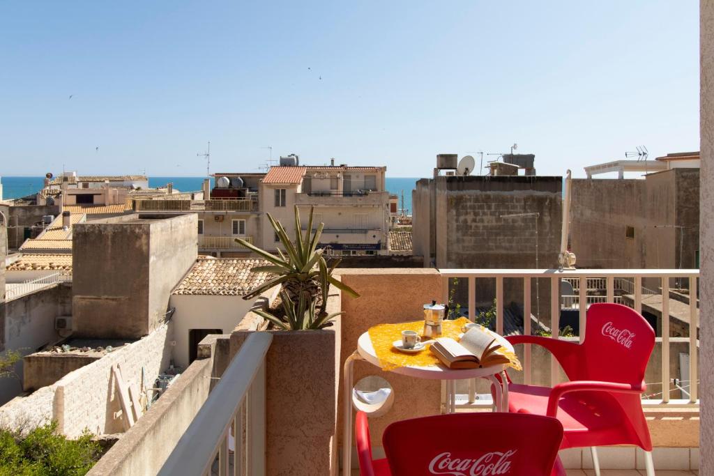 a table and chairs on a balcony with a view at Casa Riviera in Donnalucata
