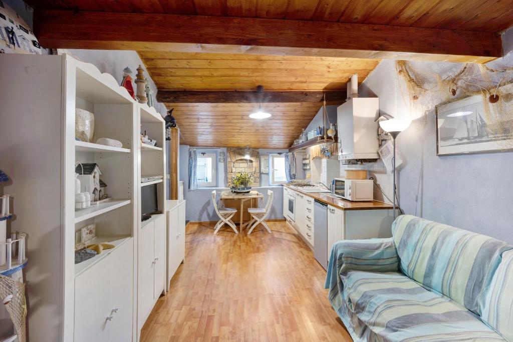 a living room with a couch and a kitchen at Mansarda Dei Pescatori in Imperia