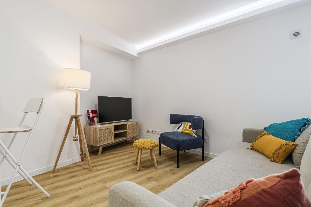 a living room with a couch and a tv at Beach House In Sesimbra in Sesimbra
