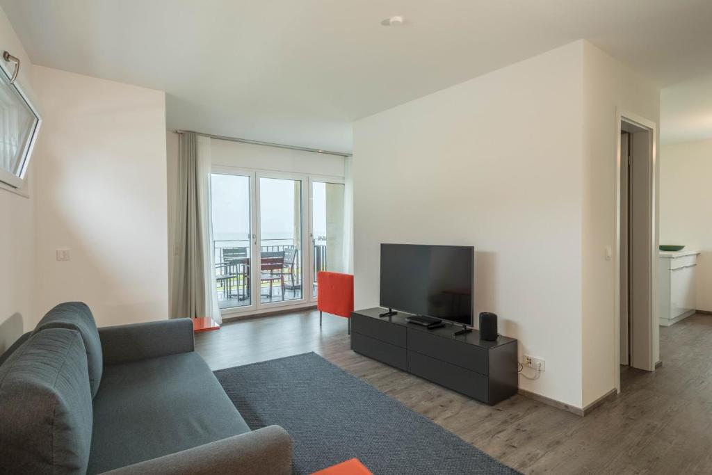 a living room with a couch and a flat screen tv at Ferienwohnung Arguna in Langenargen