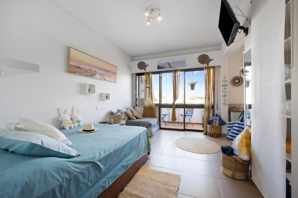 a bedroom with a bed and a living room at The Studio - Pet friendly in Alvor
