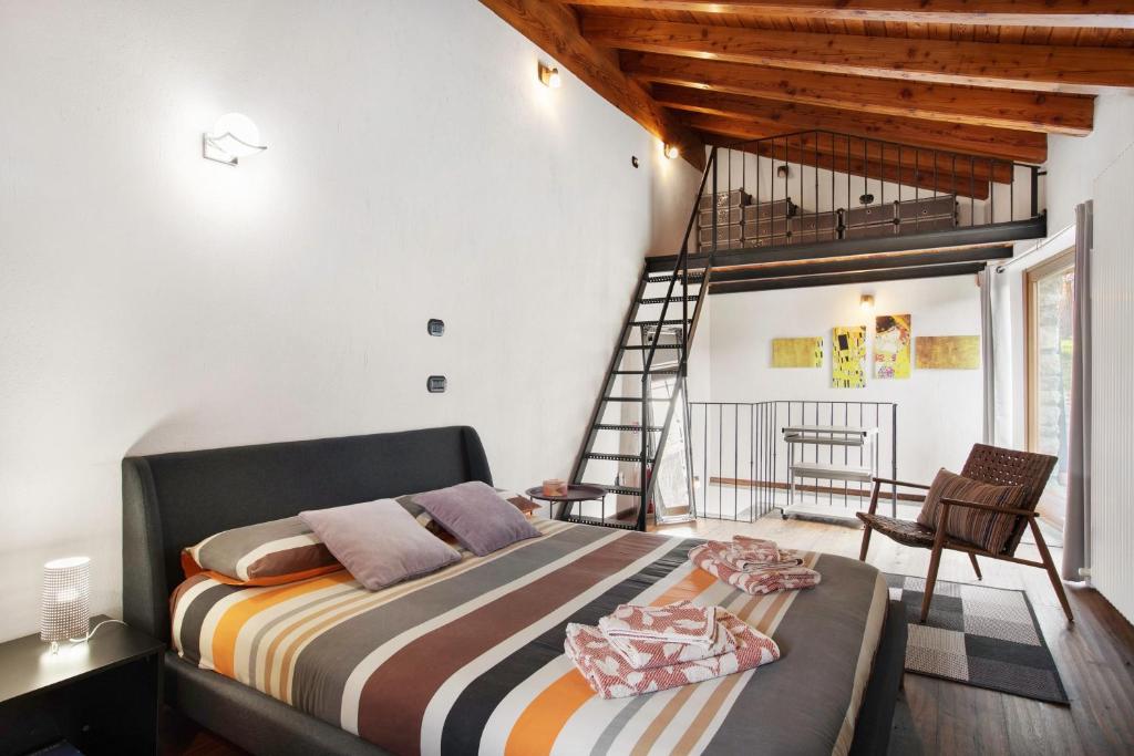 a bedroom with a bed in a room with a ladder at Mini House Valle d'Aosta in Roisan