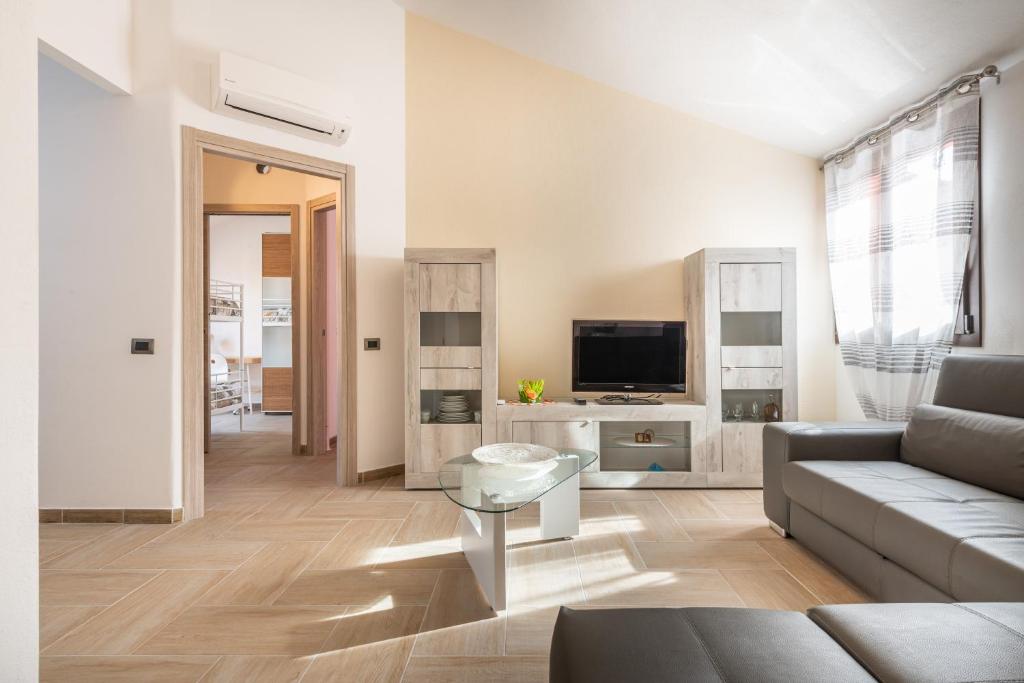 a living room with a couch and a tv at Villa Gloma in Capoterra