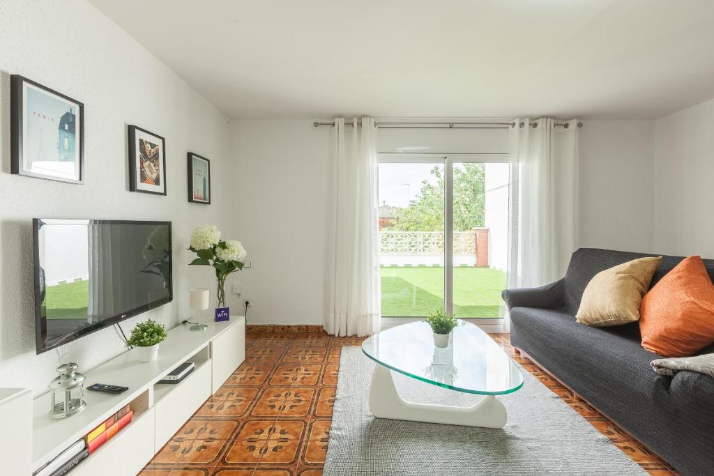 a living room with a couch and a tv at Apartamento Villa Mercedes in Rubí
