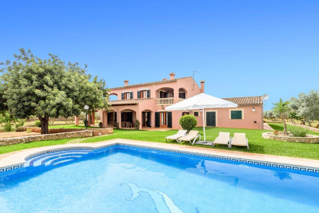 a villa with a swimming pool in front of a house at Casa Campillos in Llucmajor