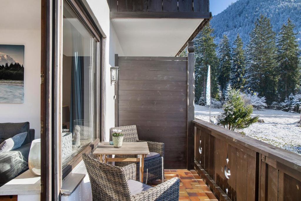 a balcony with chairs and a table with a view at Almzeit in Farchant