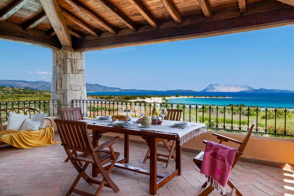 a table and chairs on a patio with a view of the ocean at Villa Ida Isuledda in San Teodoro