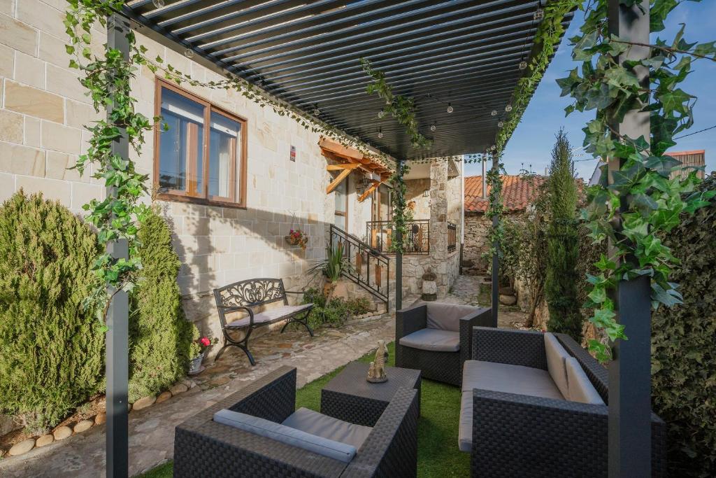 an outdoor patio with chairs and tables and a pergola at El Cedro in Abejar