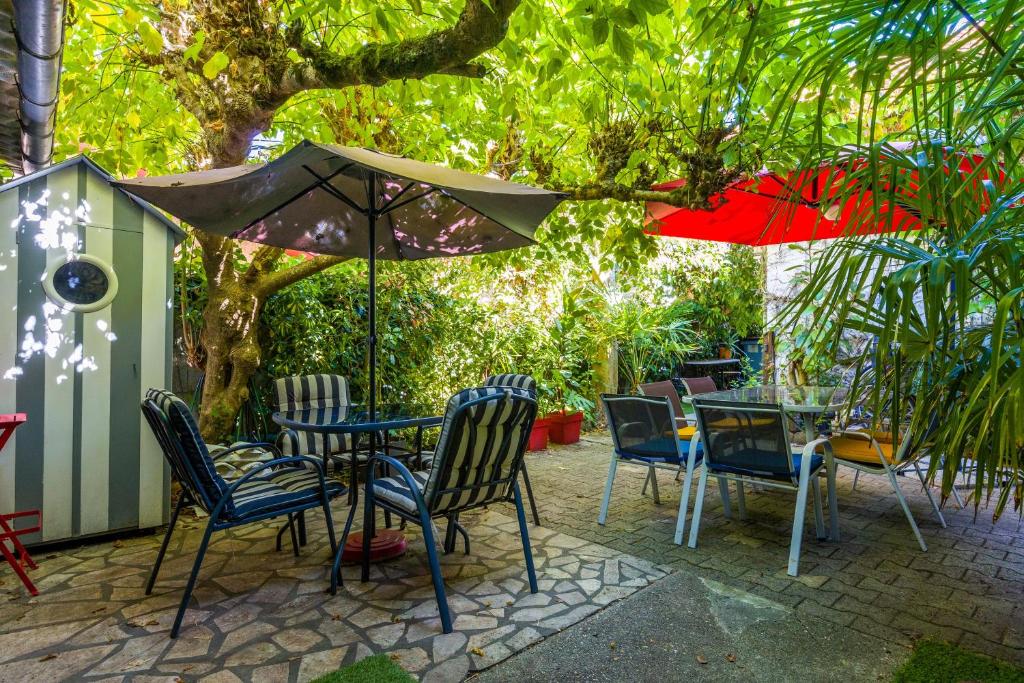 a patio with tables and chairs under an umbrella at Maison de pecheur Arcachon in Arcachon
